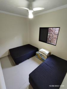 a room with two beds and a flat screen tv at Casa de Férias Praia Grande in Praia Grande