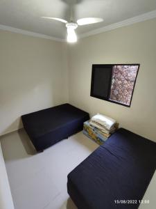 a room with two beds and a flat screen tv at Casa de Férias Praia Grande in Praia Grande +23 photos
