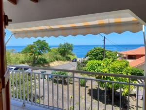 a balcony with a view of the ocean at Paradyse Den's près Sources d'Eau Chaudes , Paisible , Vue sur mer , WIFI in Bouillante