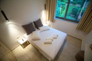 sypialnia z białym łóżkiem i ręcznikami w obiekcie Elea resort w Prewezie