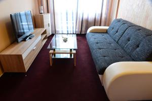 a living room with a blue couch and a table at Hotel Ďumbier in Brezno