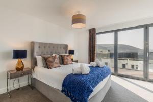a bedroom with a bed and a large window at 8 Challacombe - Luxury Apartment at Byron Woolacombe, only 4 minute walk to Woolacombe Beach! in Woolacombe +36 photos
