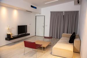 a living room with a couch and a tv at Elea resort in Preveza