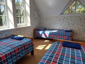 a room with two beds and two windows at Vainupea puhkemaja in Vainupea