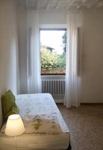 a bedroom with a bed and a window at Casa di Canfreo in Lari