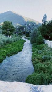 un flusso d’acqua con un ponte sullo sfondo di Residence il giardino sul fiume Nera a Cerreto di Spoleto