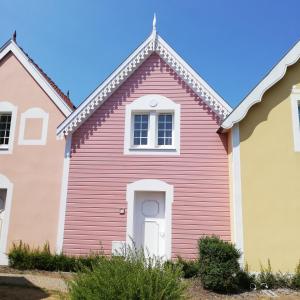 uma casa vermelha com uma porta branca em La Maison Rose em Fort-Mahon-Plage