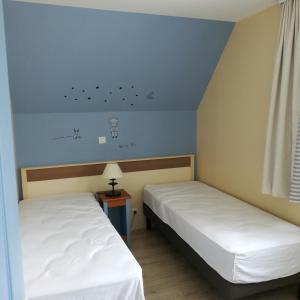 2 camas individuais num quarto com uma janela em La Maison Rose em Fort-Mahon-Plage