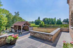 een tuin met een tuinhuisje en een bank bij Huize Koedoe in Tongeren