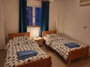 - 2 lits dans une chambre avec des serviettes bleues dans l'établissement Large apt 2 bedrooms sea view & 2 balconies, à Larnaka