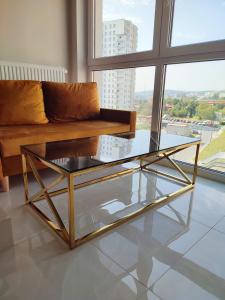 una mesa de centro de cristal en una sala de estar con sofá en Apartament blisko morza Gdansk Nowa Letnica Apartament close by the Sea Gdansk Appartement am Meer Gdansk, en Gdansk