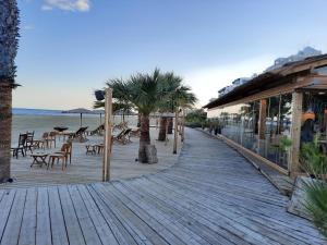- une promenade en bois avec des chaises et des arbres sur la plage dans l'établissement Large apt 2 bedrooms sea view & 2 balconies, à Larnaka