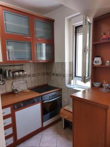 a kitchen with wooden cabinets and a stove top oven at Apartment Music-center, in the center of Podgorica in Podgorica