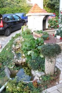 un jardín con un estanque y una casa de aves en Ivan & Anka apartments BOJKO, en Selce