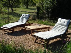 2 chaises et une table basse dans la cour dans l'établissement MAISON ATYPIQUE AVEC JARDIN AU PIED DU CLOS LUCE, à Amboise