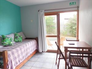 a bedroom with a bed and a table and a window at Terrazas de Aguas Dulces in Aguas Dulces