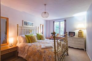 a bedroom with a bed and a dresser and a television at The Coach House by Bloom Stays in Harrietsham