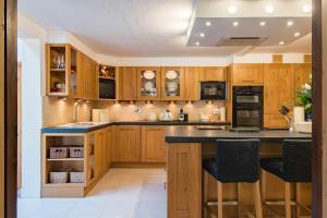 a kitchen with wooden cabinets and black countertops at The Coach House by Bloom Stays in Harrietsham