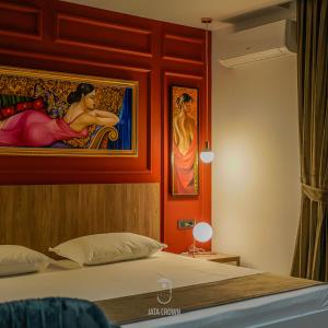 - une chambre avec un lit orné d'une peinture murale dans l'établissement Jata Crown Hotel, à Tirana