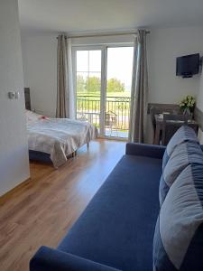 een woonkamer met een bank en een bed en een balkon bij Villa Over Lake in Mielno