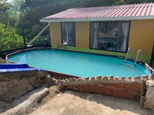a large blue swimming pool in front of a house at Finca Peñitas in Boquerón de Capira