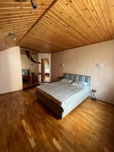 a large bedroom with a bed and a wooden ceiling at Casa Centru Chișinău in Chişinău