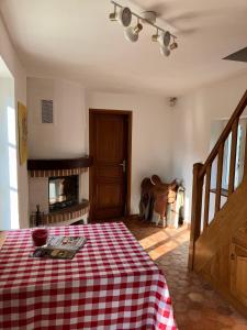 una habitación con un mantel rojo y blanco a cuadros en una cama en La petite maison de la vallée, en Bazainville