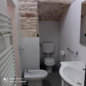 bagno bianco con servizi igienici e lavandino di CASA LARI a Martina Franca