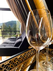 two wine glasses sitting on top of a balcony at Cold Land Chalé in Urubici