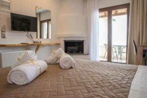 a hotel room with a bed with towels on it at Aelia Mount Suites in Zagora