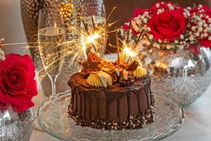 a chocolate cake with sparklers on a table with roses at The Nestle House in Winchester