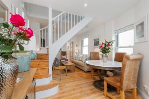 a living room with a table and a staircase at The Nestle House in Winchester