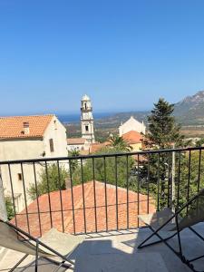 d'un balcon avec vue sur un bâtiment et une tour de l'horloge. dans l'établissement Casa Calenzana, à Calenzana