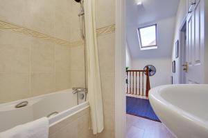 a bathroom with a bath tub and a sink at Talbot Woods Villa in Bournemouth
