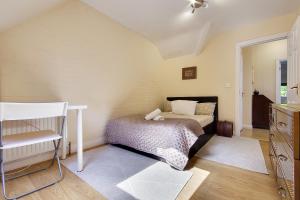 Talbot Woods Villa في بورنموث: غرفة نوم فيها سرير وكرسي