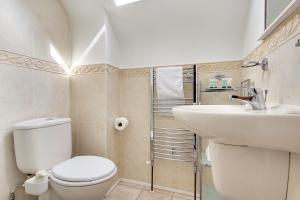 uma casa de banho com um WC branco e um lavatório. em Talbot Woods Villa em Bournemouth