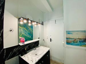 uma casa de banho com um lavatório e um espelho em Appartement Vert du Palais - Relaxation Centrale em Palais