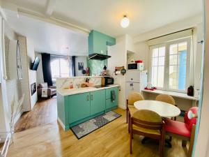 a kitchen with green cabinets and a table and chairs at Appartement Vert du Palais - Relaxation Centrale in Le Palais