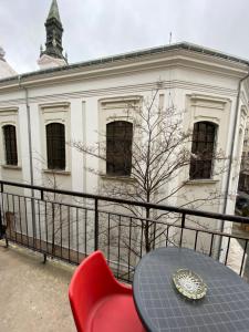 a table and a red chair in front of a building at Apartment with Balcony and AC next to Danube in Budapest