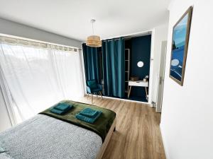 a bedroom with a bed and a desk in a room at Villa Simone vue mer 2min à pied de la plage in Saint-Lunaire