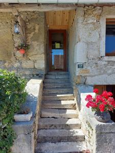 een stenen gebouw met een trap naar een deur bij Gîte 11 personnes avec extérieur in Saint-Maurice-de-Rotherens
