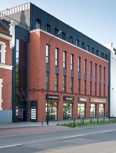 a red brick building with a street in front of it at Apartamenty Dworcowa 60 in Gliwice +65 photos