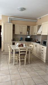uma cozinha com uma mesa branca e cadeiras em Casa Mimì em Arsago Seprio