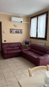 a living room with two brown leather couches at Casa Mimì in Arsago Seprio