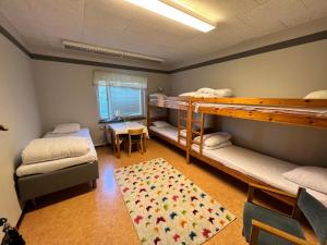 a room with two bunk beds and a rug at Vandrarhem Oden in Odensbacken