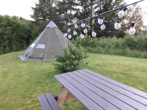 a picnic table and a tent in a field at Leite Telt Camping in Lyngstad +12 photos