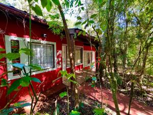 a red house in the middle of the forest at Cabañas Luces De La Selva in Puerto Iguazú