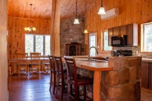 a kitchen with a large island in a wooden house at Chalet L'Envolée near Tremblant in Saint-Faustin