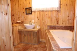 a bathroom with a tub and a sink at Chalet L'Envolée near Tremblant in Saint-Faustin +23 photos