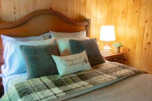 a bedroom with a bed with a wooden headboard at Chalet L'Envolée near Tremblant in Saint-Faustin